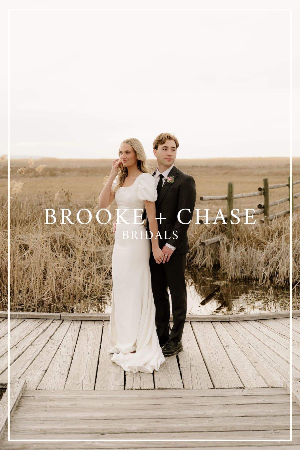 Wedding couple stands together on a wooden deck surrounded by golden grassy fields at sunset.