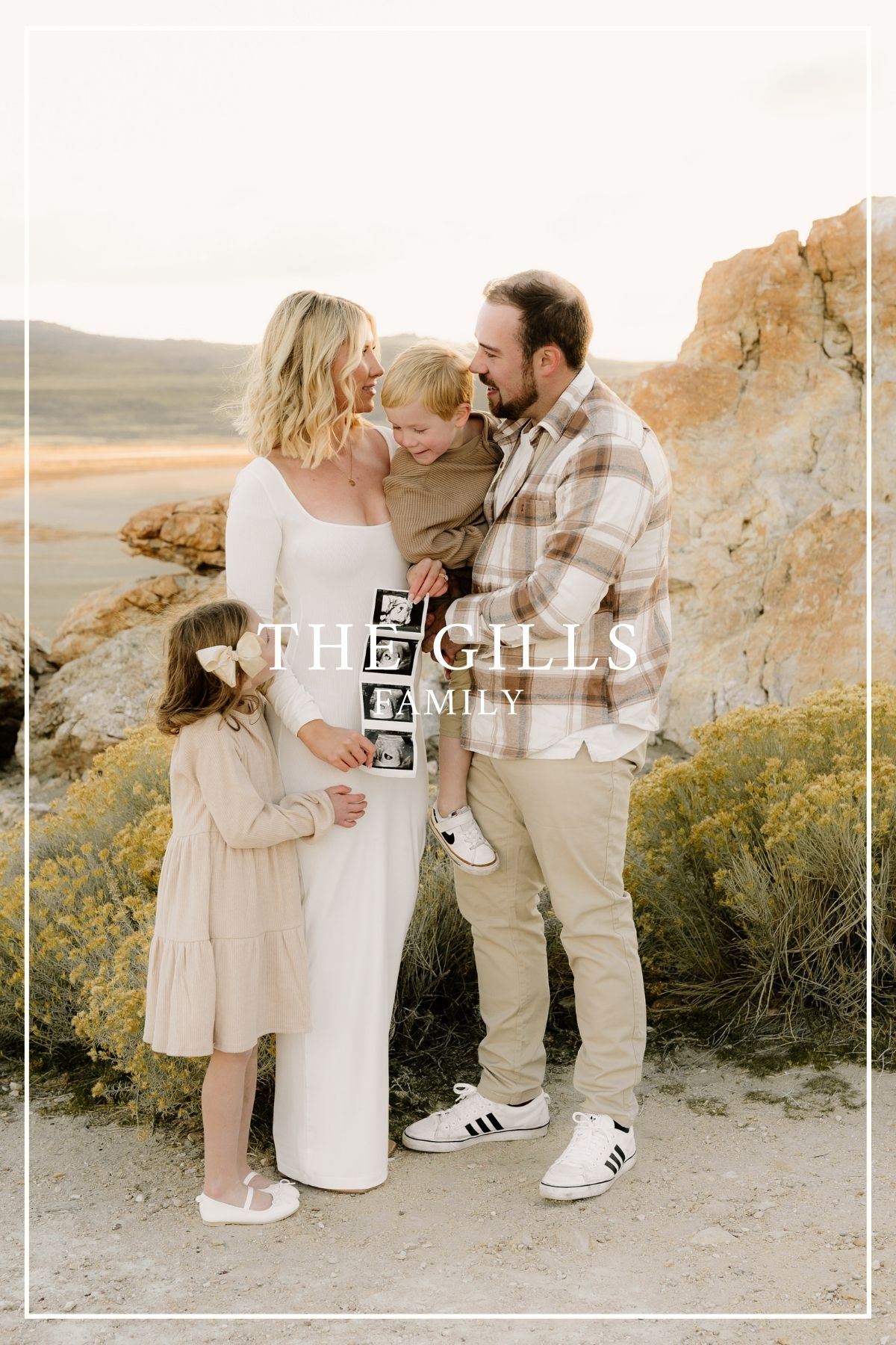 A loving family sharing a tender moment together in a natural desert landscape against a rock formation at sunset.