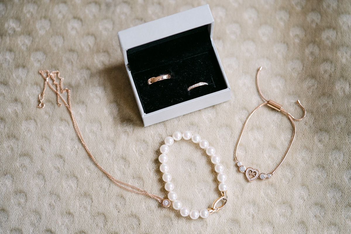 Bridal jewelry and wedding rings flatlay before ceremony.