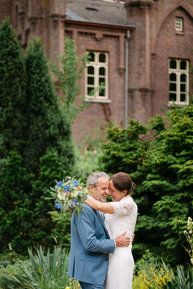 Groom and bride hugging in the gardens of Kasteel Aerwinkel.