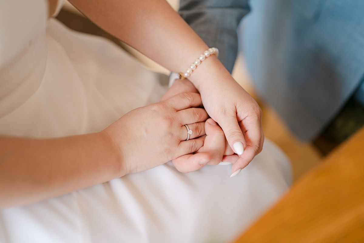 Joined hands during vows; tender ceremony detail.