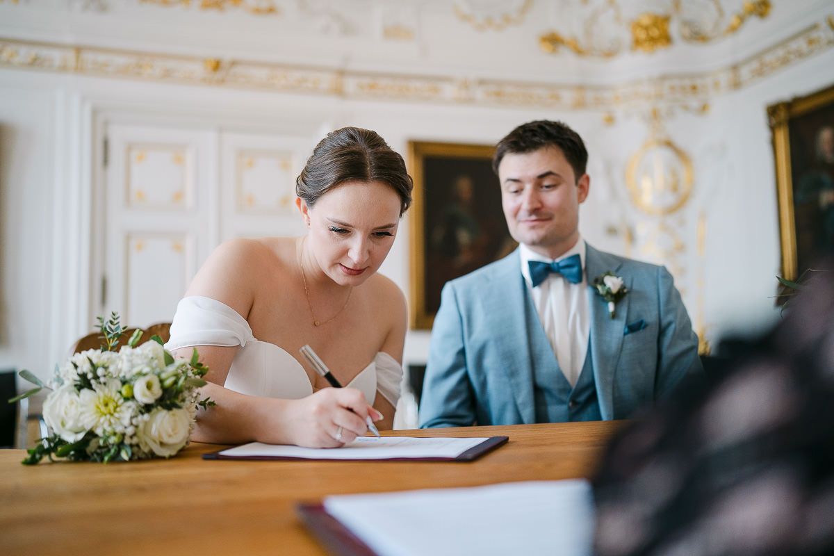 Bride signing the register at the registrar’s desk.
