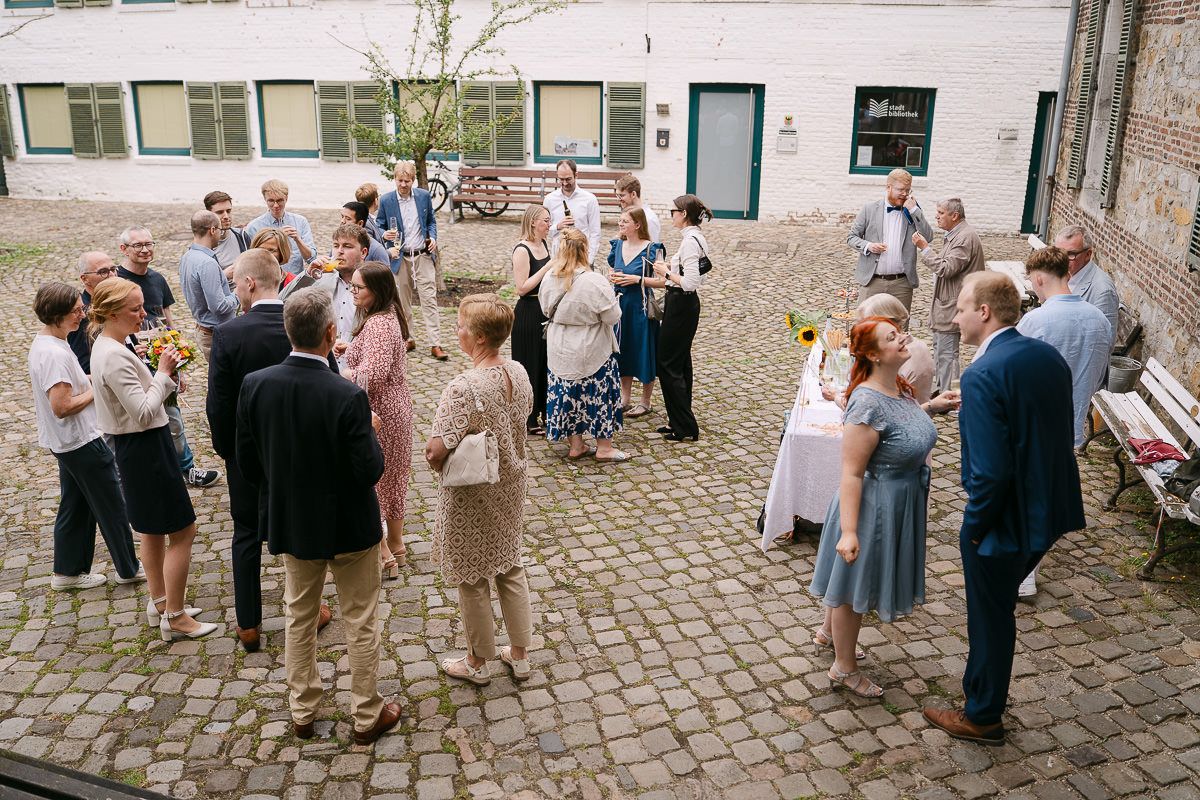 Sektempfang im Innenhof der Welschen Mühle in Aachen Haaren nach der standesamtliche Hochzeit.