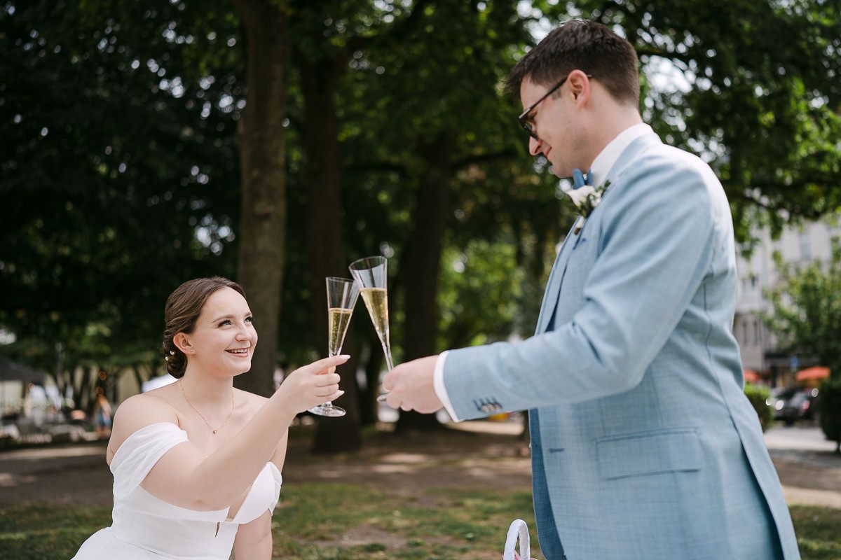 Cheerful champagne toast during picnic after civil wedding.