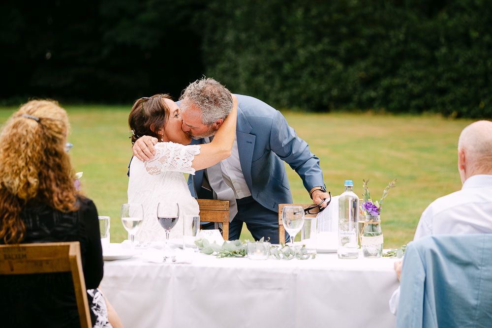 Bride and groom kissing during the wedding dinner at Kasteel Aerwinkel.