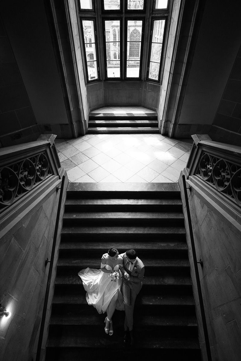 Brautpaar sitzt auf der großen Treppe im Rathaus Aachen in einer interessanten und dramatischen Bildkomposition.