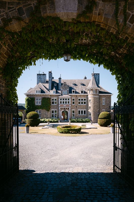 Exterior view of Manoir de Lébioles castle on wedding day with archway