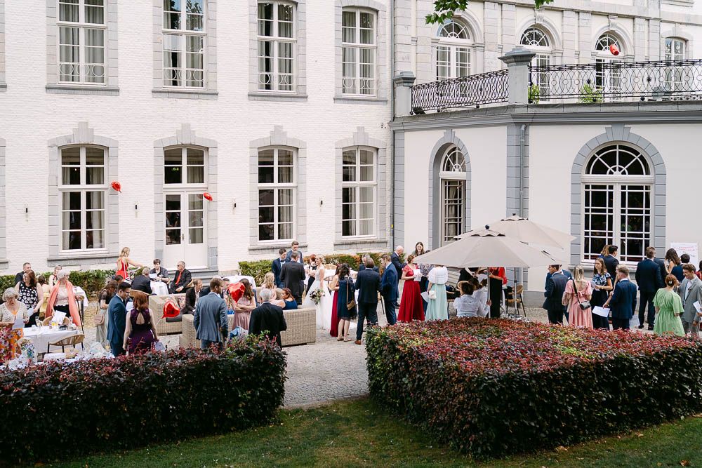Hochzeitsgäste beim Sektempfang auf der Terrasse des Kasteel Bloemendal in Vaals.
