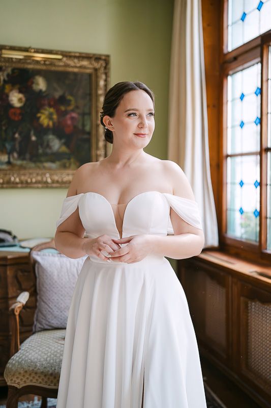 Elegant posed bridal portrait by the window with natural light.