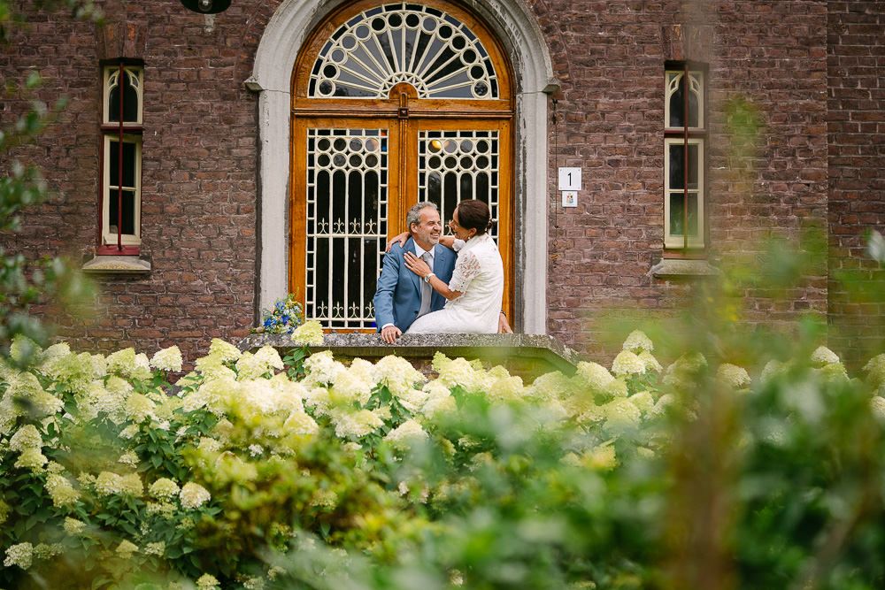 Romantic couple portrait surrounded by blooming flowers at Kasteel Aerwinkel.