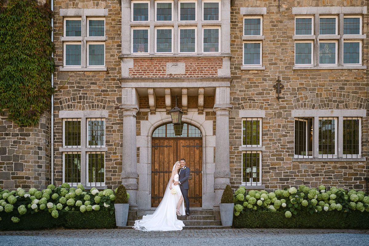 Bride and groom portrait at entrance of Manoir de Lébioles