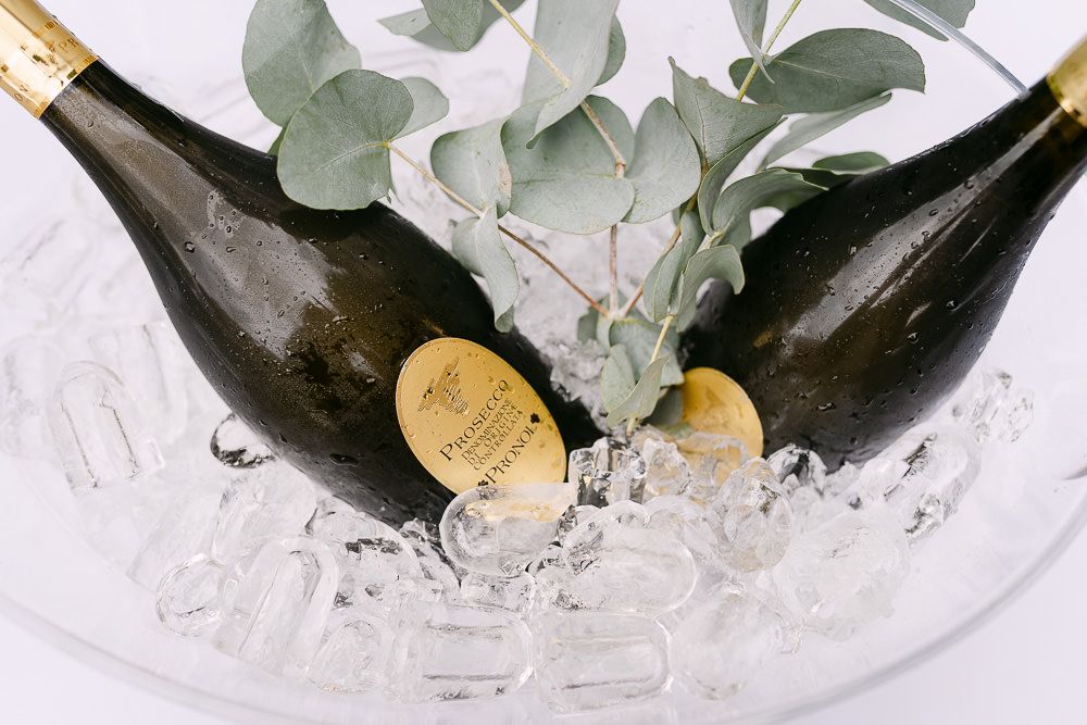 Chilled champagne bottles with greenery in an ice bucket for the wedding celebration at Kasteel Aerwinkel.