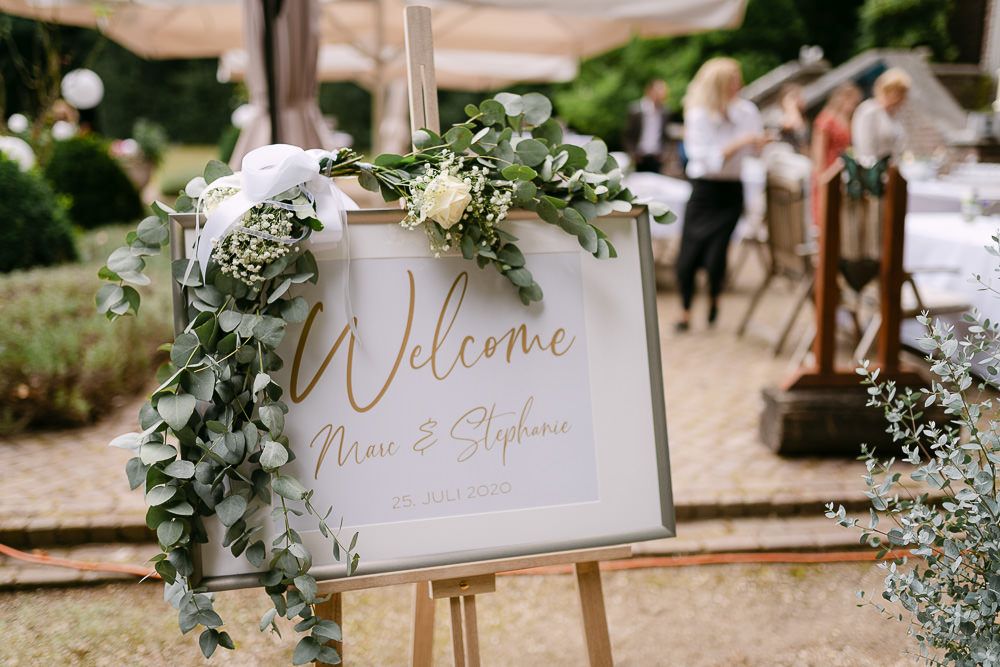 Stylish wedding welcome sign decorated with greenery at Kasteel Aerwinkel.