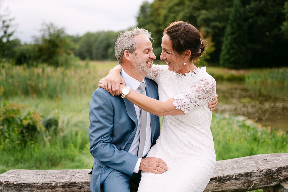 Bride and groom sitting together in the park of Kasteel Aerwinkel, enjoying a quiet moment.