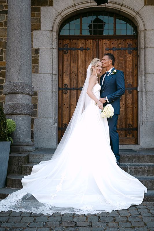 Bride and groom portrait at entrance of Manoir de Lébioles