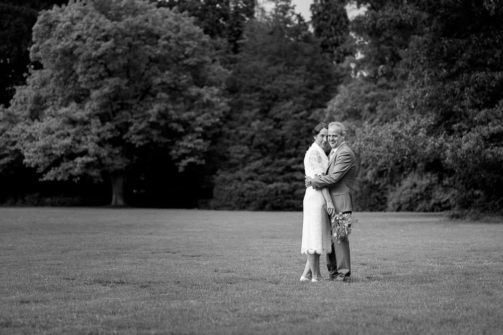 Black and white photo of the couple embracing in the gardens of Kasteel Aerwinkel.