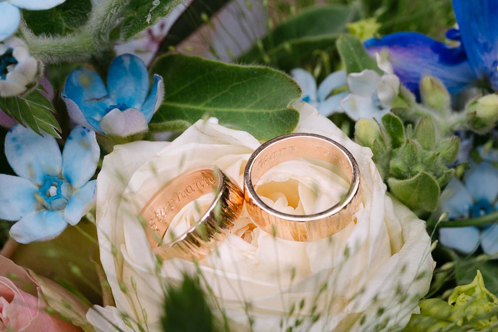 Close-up of wedding rings on a floral arrangement at Kasteel Aerwinkel.