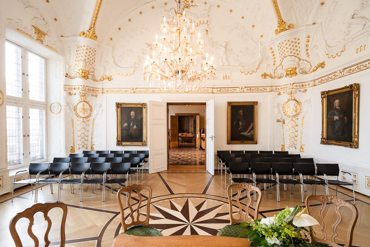 Prunkvolles Interieur eines barocken Palastes mit Kristalllüstern, vergoldeten Details und weißen Wänden im luxuriösen europäischen Stil.