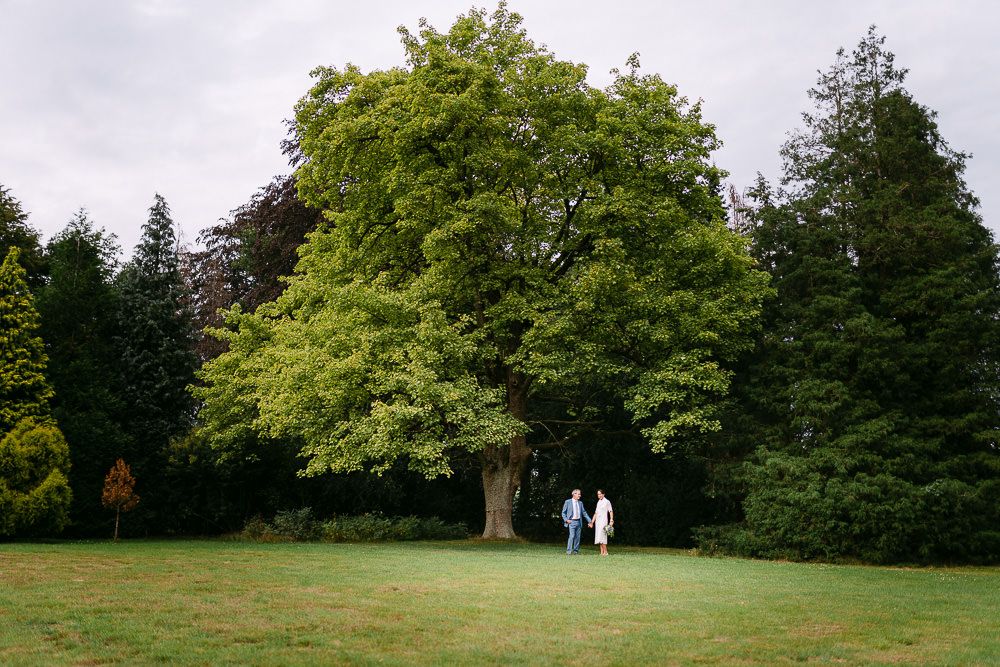 Bride and groom walking across the vast park landscape of Kasteel Aerwinkel.