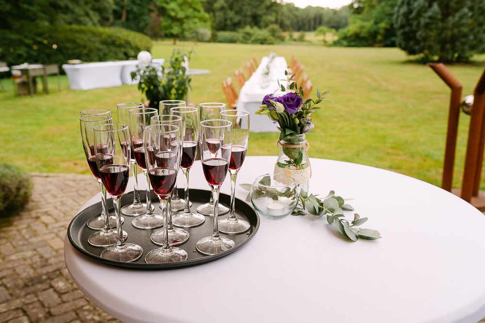 Glasses of red champagne on a table prepared for wedding welcome drinks at Kasteel Aerwinkel.