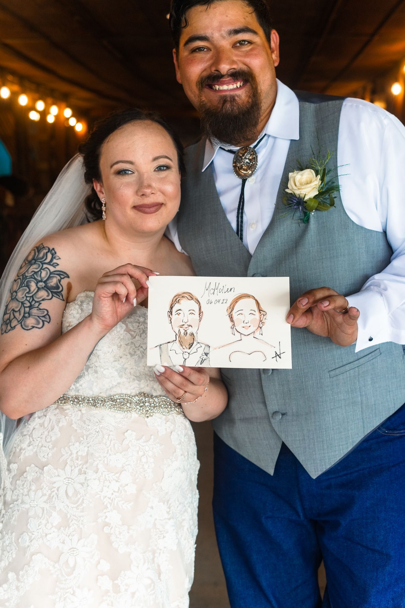 Bride and groom holding a caricature drawing of themselves at their wedding reception.