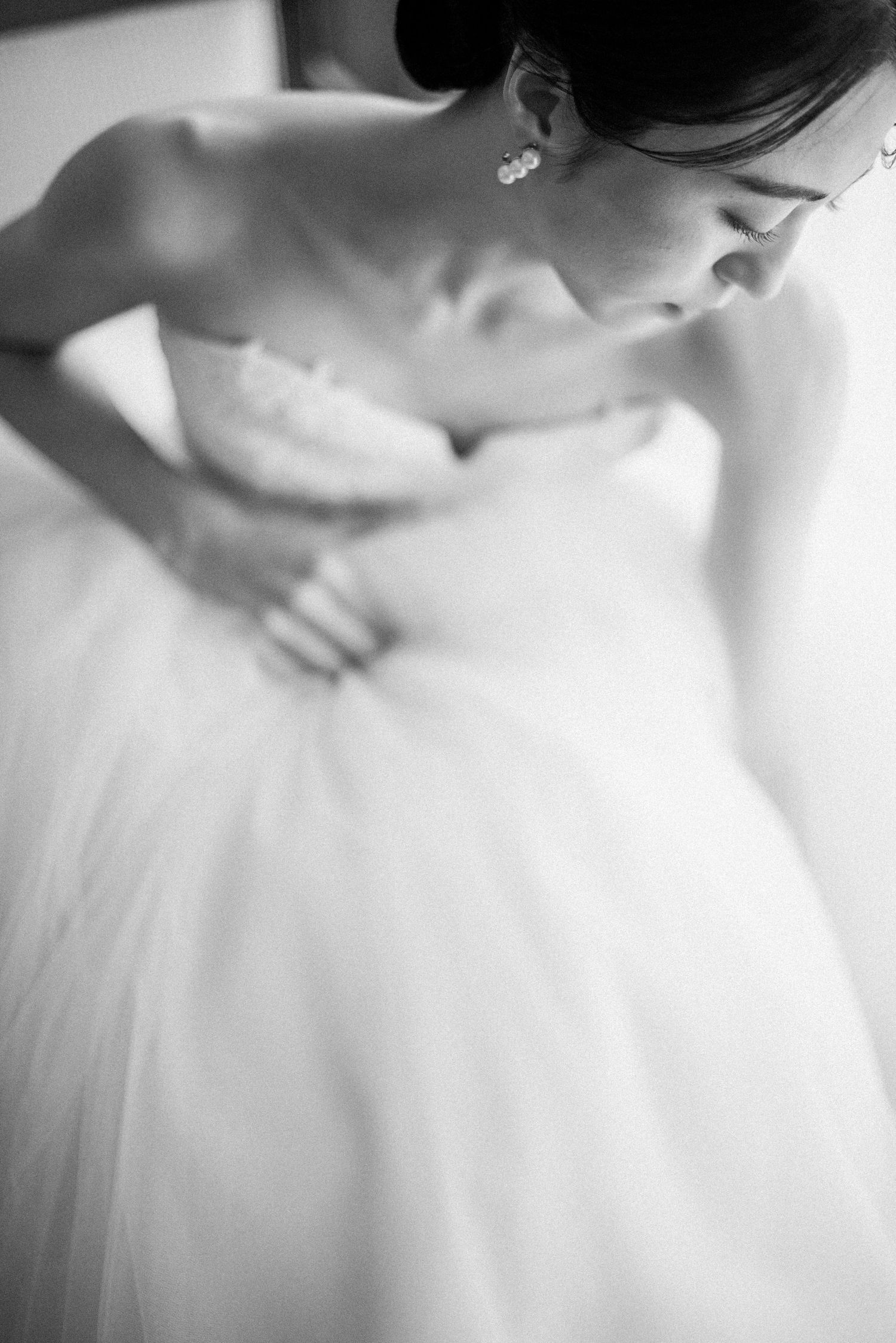 Black and white detail of a bride getting ready in her wedding dress