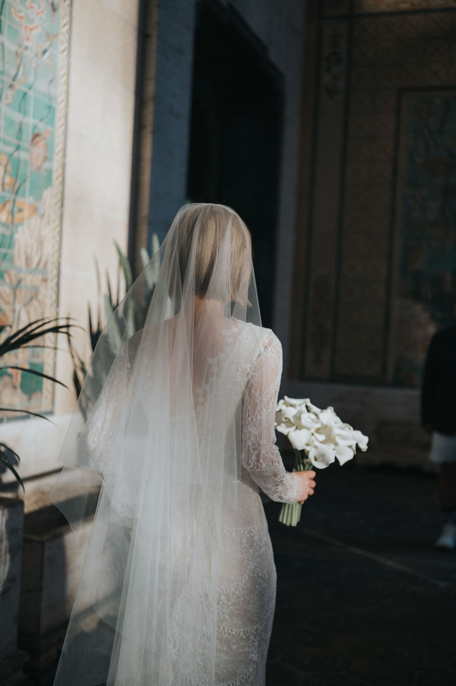 Bride holding a white bouquet outside a historic building in Honolulu