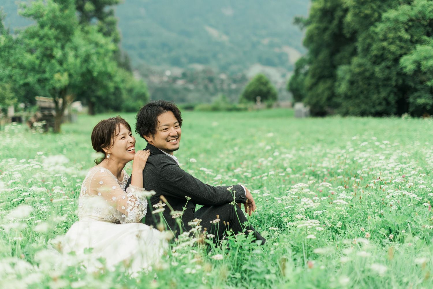 Newlywed couple sitting together in a meadow during a destination wedding in Switzerland