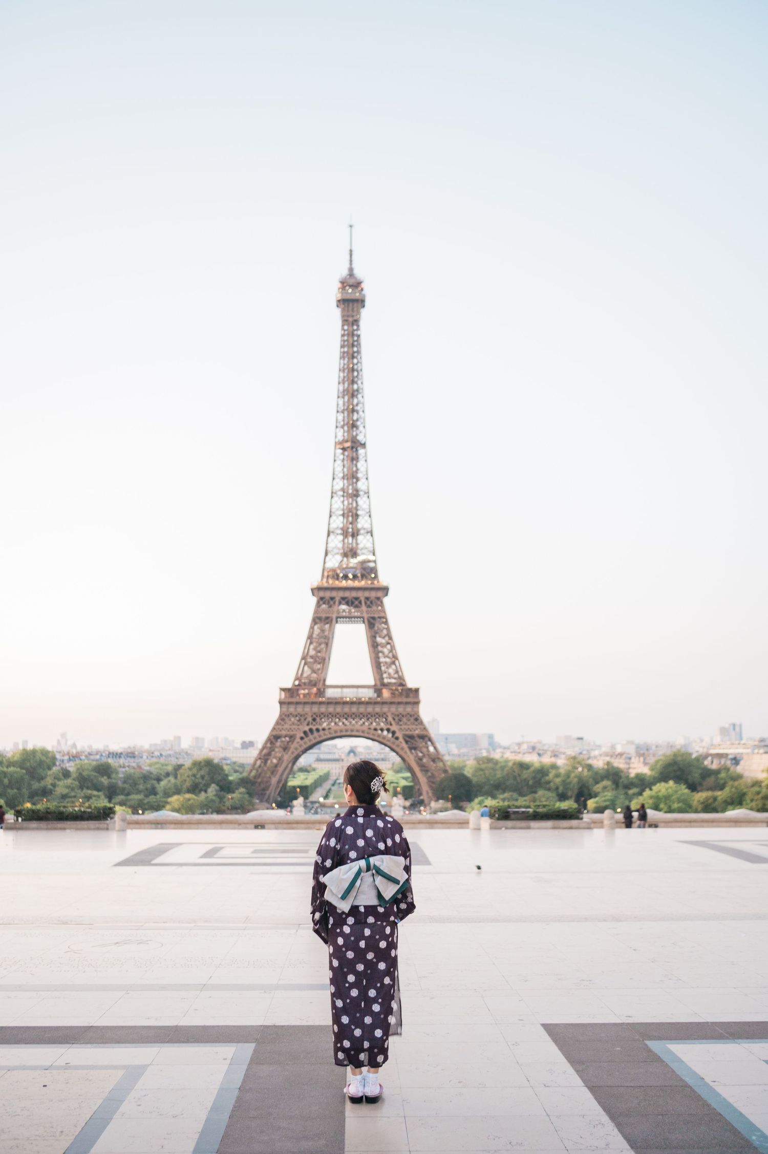 Woman standing in front of the Eiffel Tower in Paris, France