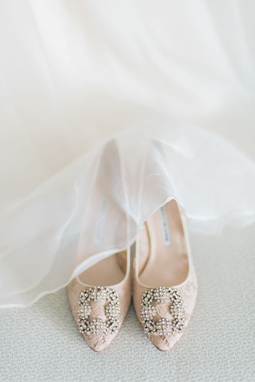 Close-up of a bride’s wedding shoes beneath her dress