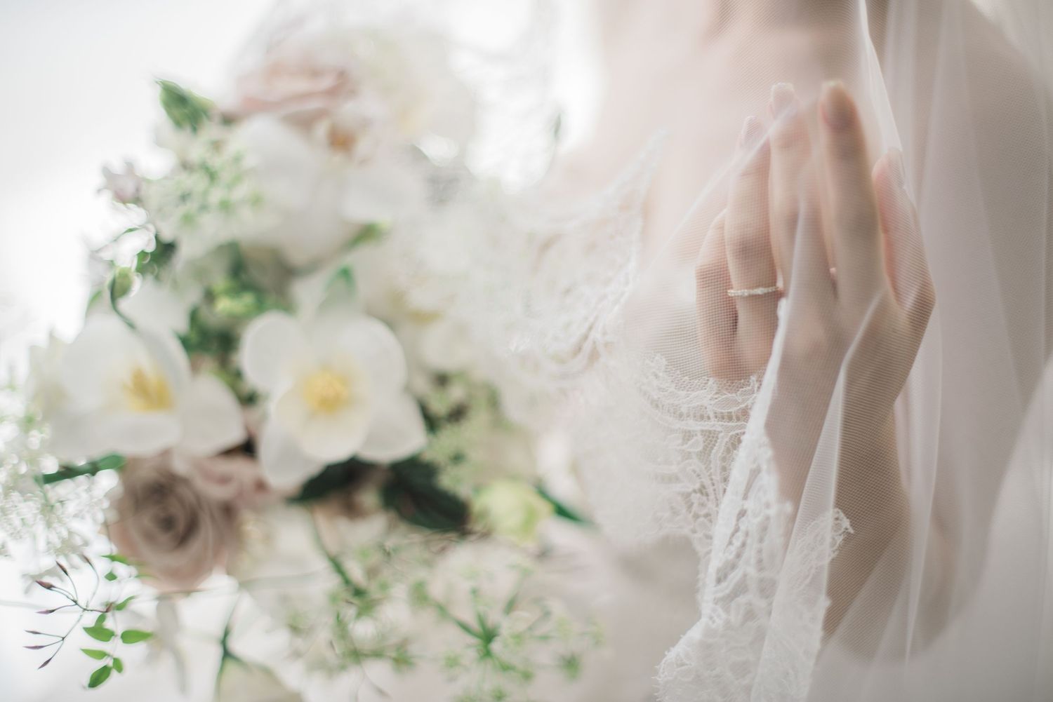 Soft bridal portrait with a wedding bouquet and lace veil