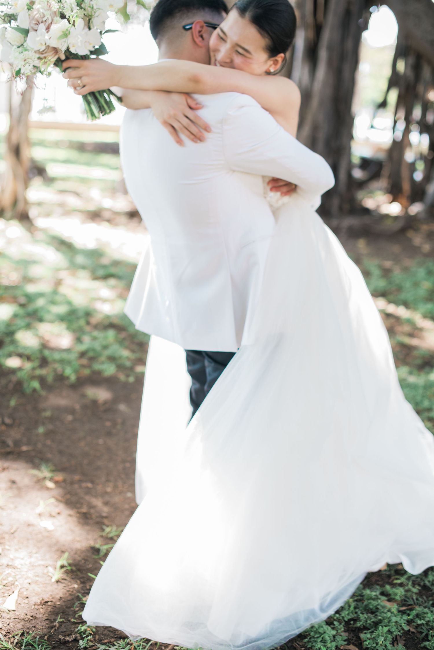 Bride and groom embracing during an outdoor wedding in Hawaii