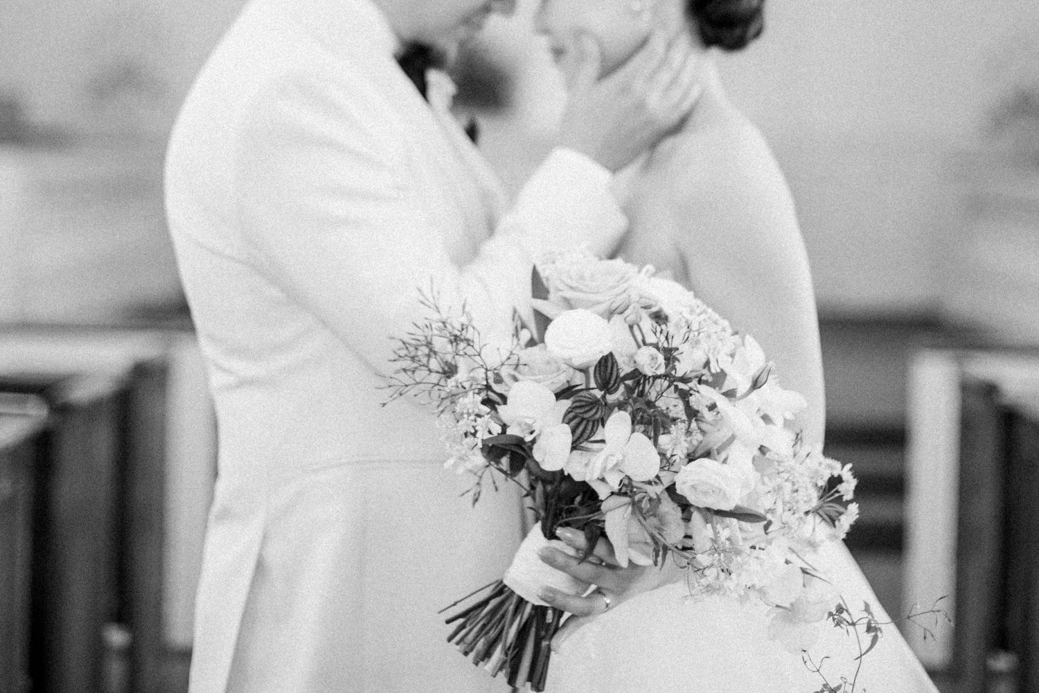 Black and white close-up of a newlywed couple embracing