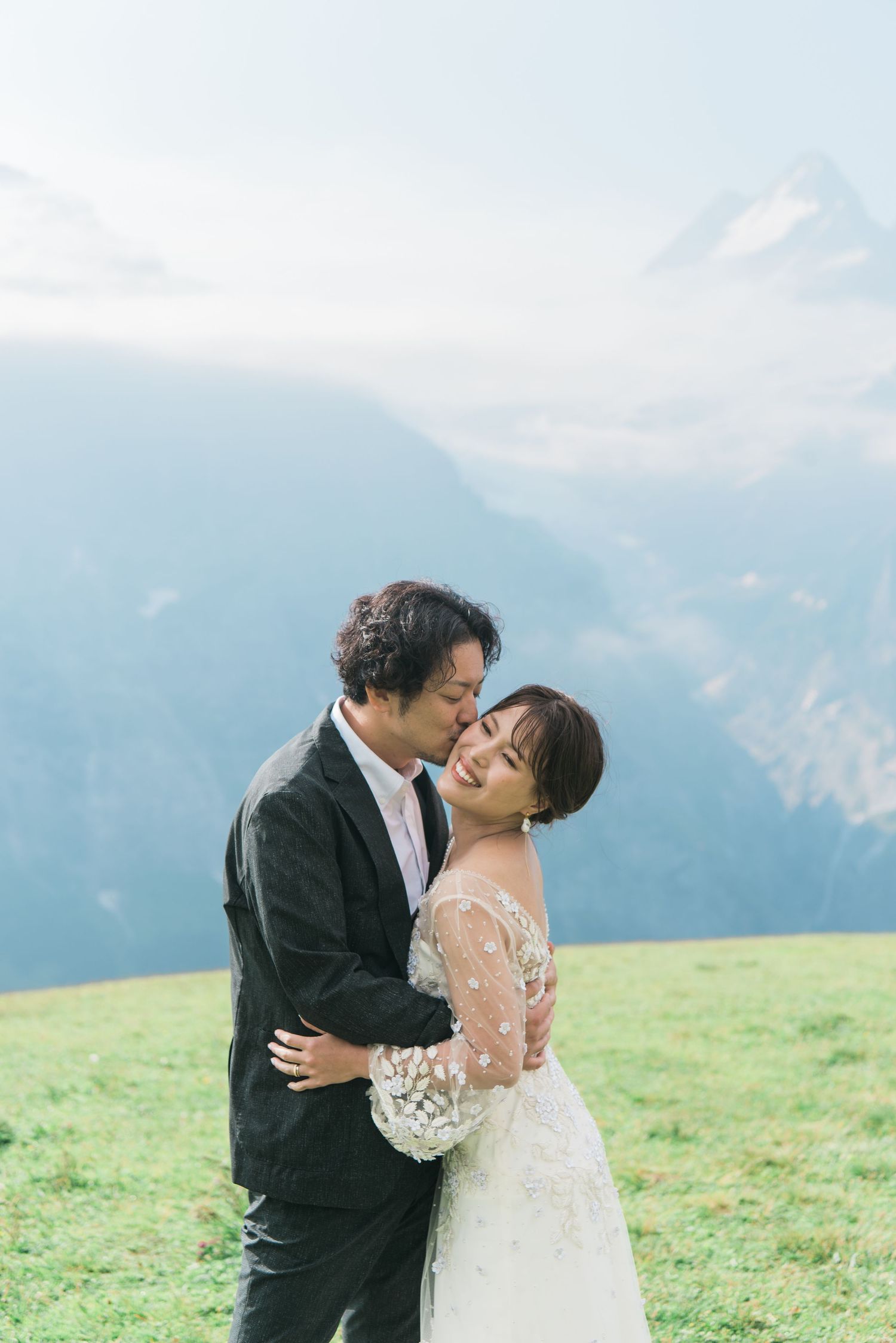 Newlywed couple embracing in a mountain meadow in Switzerland
