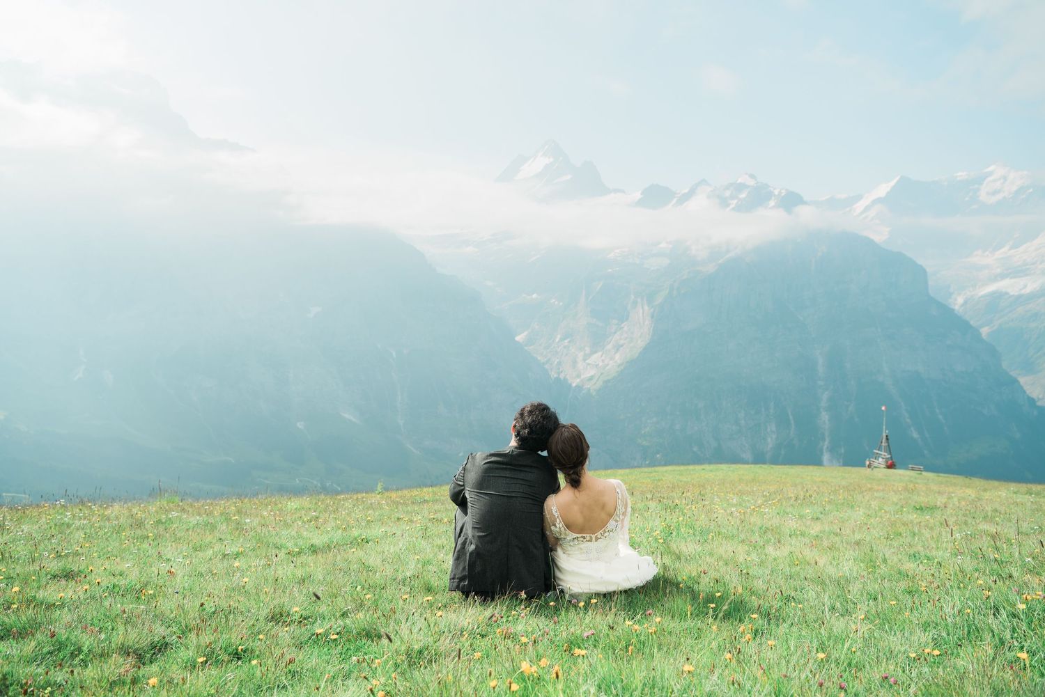 Newlywed couple sitting together overlooking the Swiss Alps