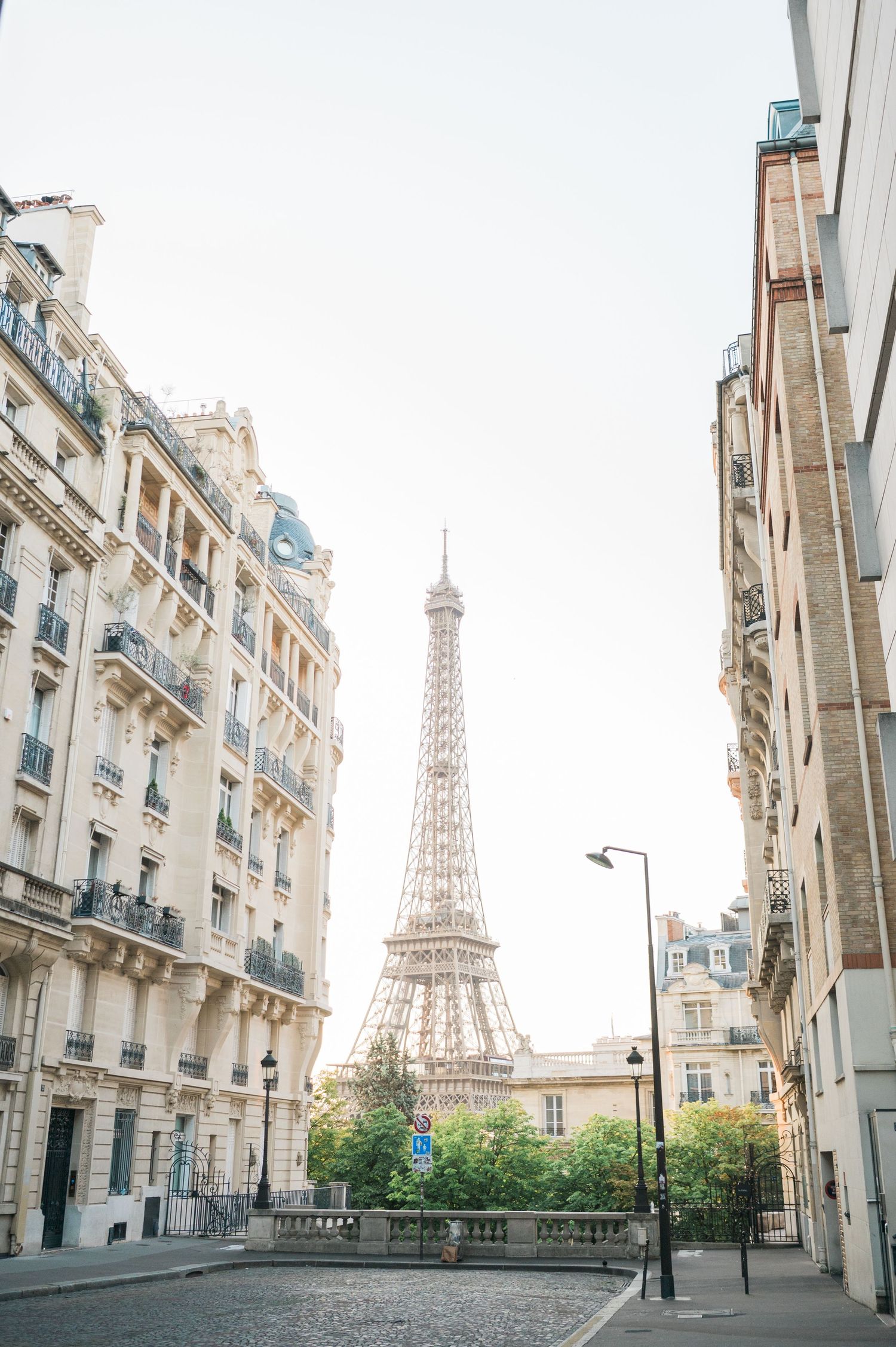 Eiffel Tower viewed between classic Parisian buildings