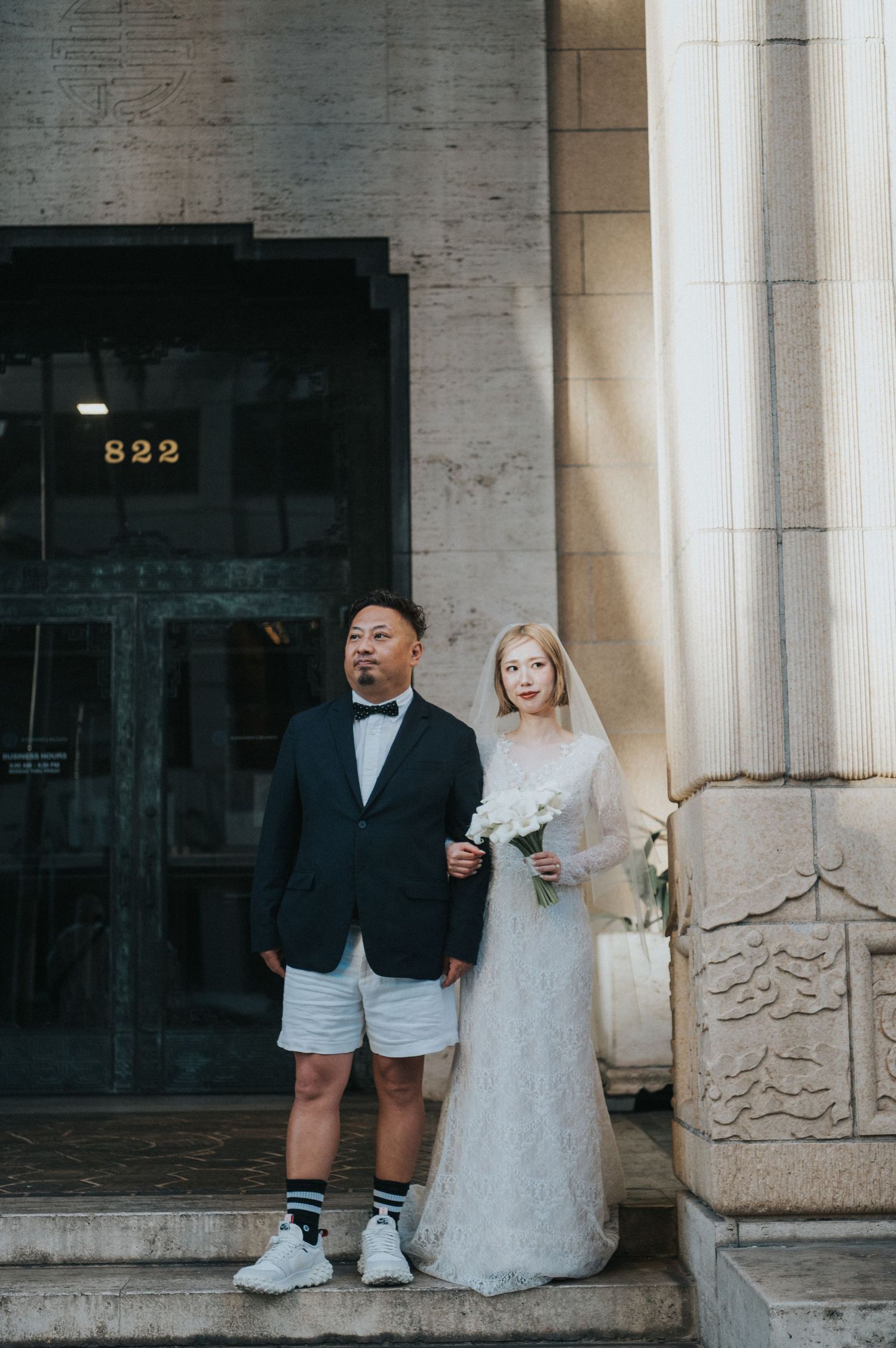 Newlywed couple posing outside a historic building in downtown Honolulu