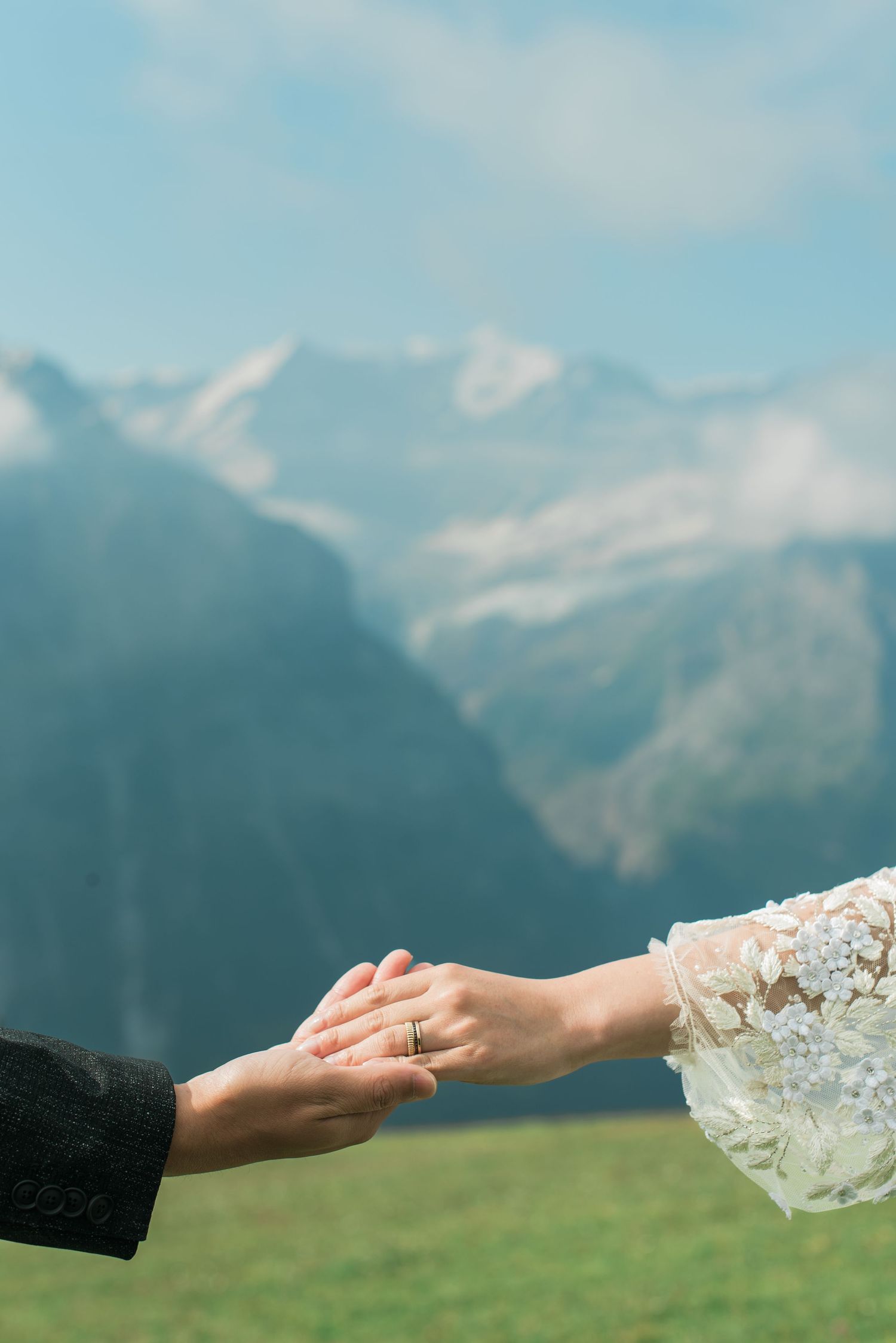 Newlywed couple holding hands with the Swiss Alps in the background