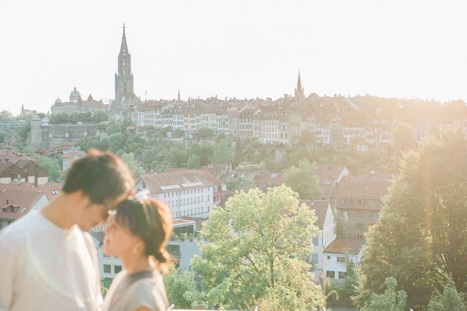 Couple sharing an intimate moment overlooking a European city at sunset