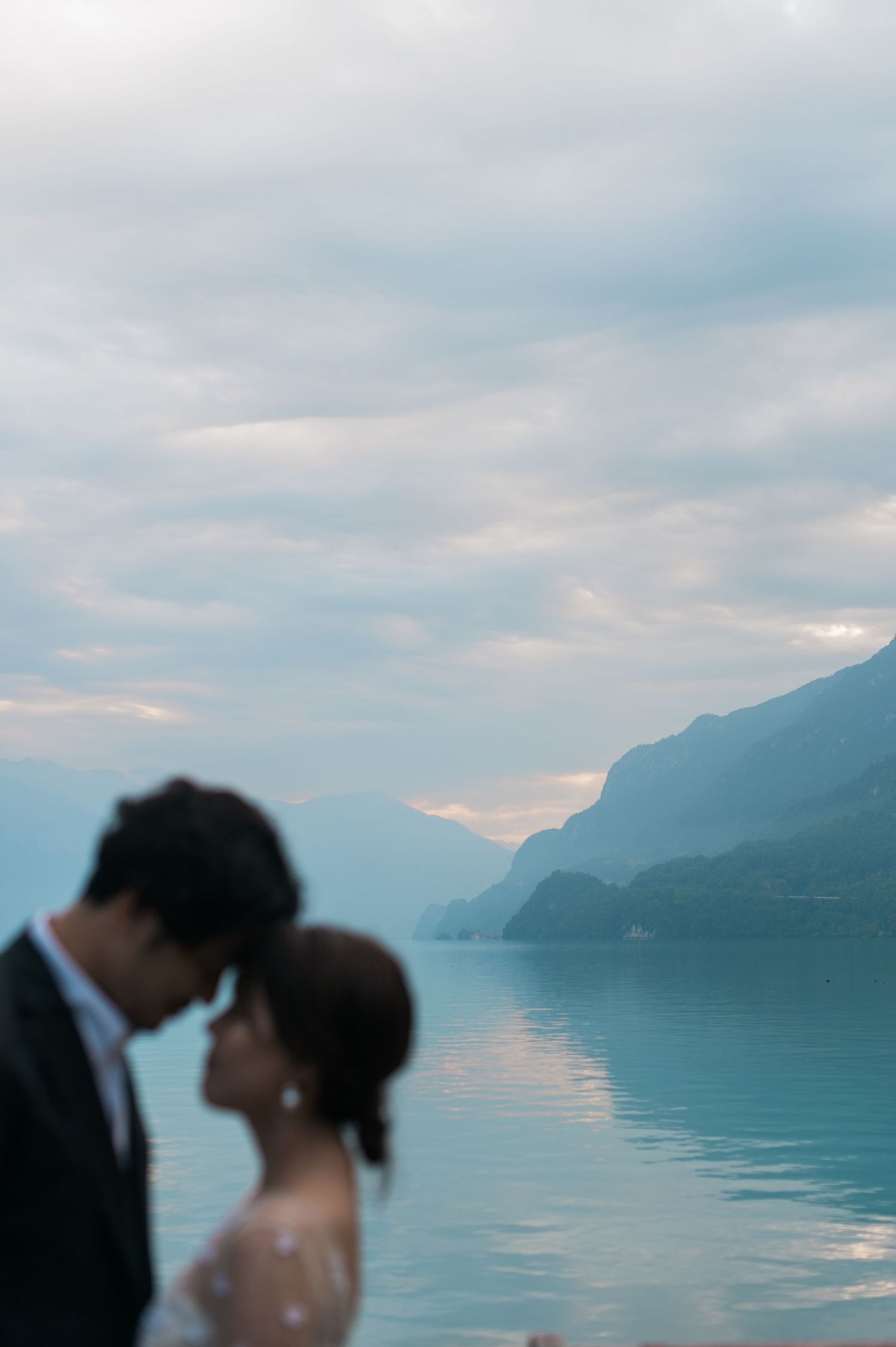 Newlywed couple sharing a quiet moment by a lake in the Swiss Alps