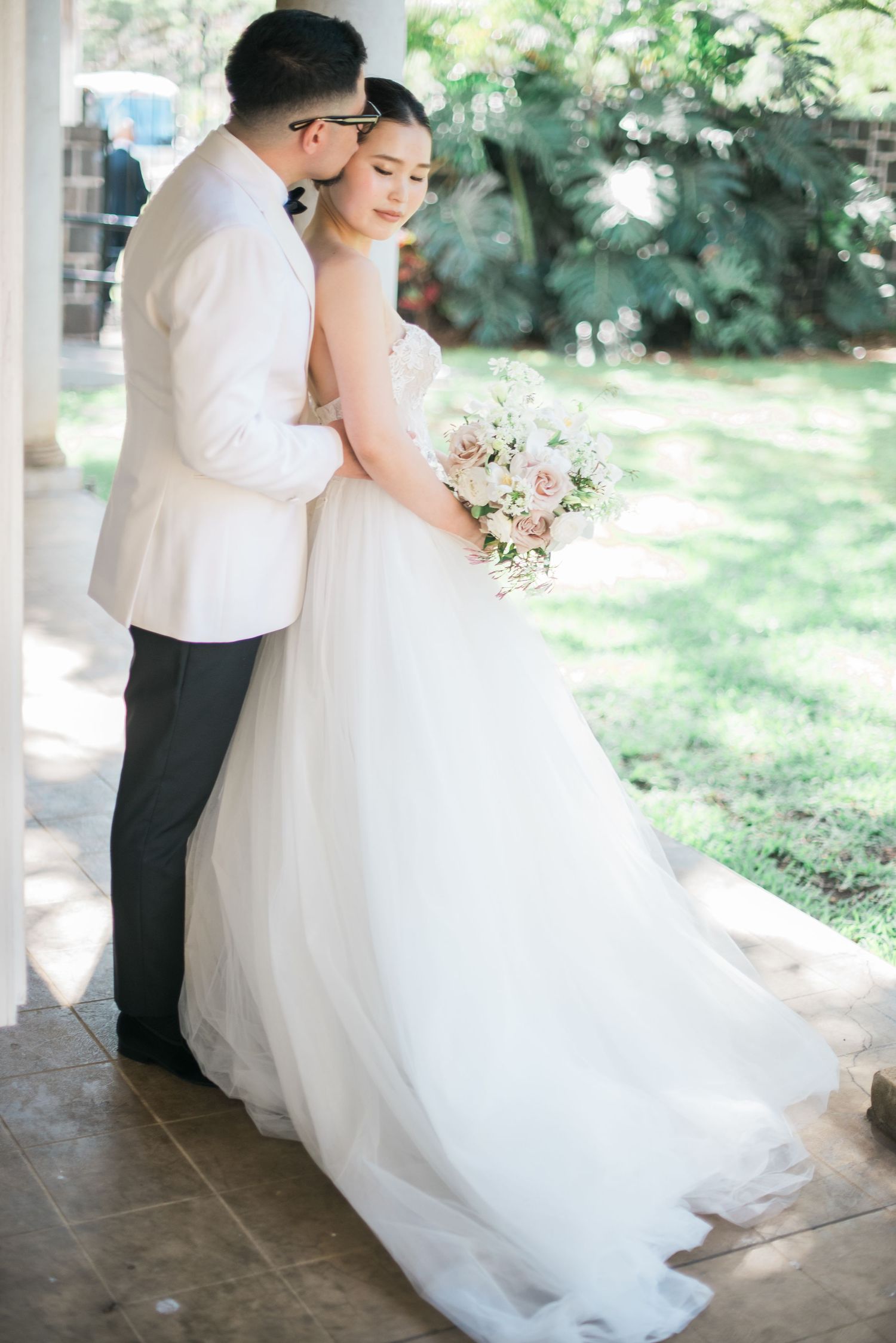 Bride and groom embracing during an outdoor wedding portrait in Hawaii
