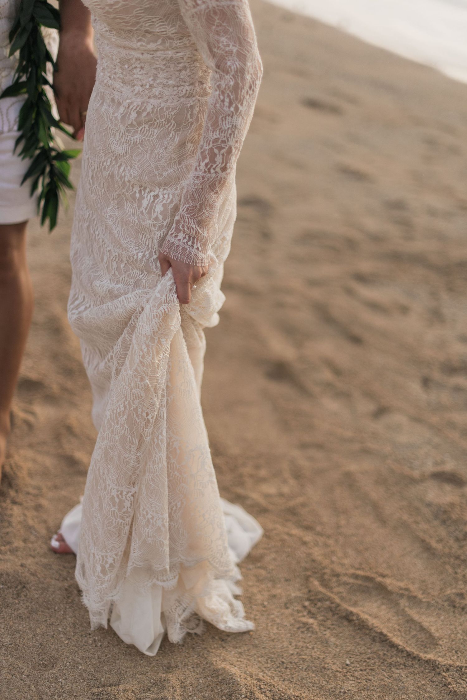 Detail of a bride’s lace wedding dress during an outdoor Hawaii wedding