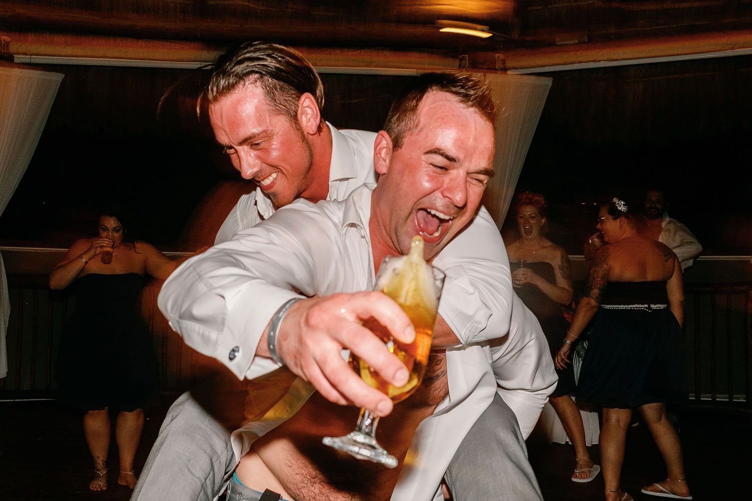 Scott laughing and dancing with a guest at the palapa reception