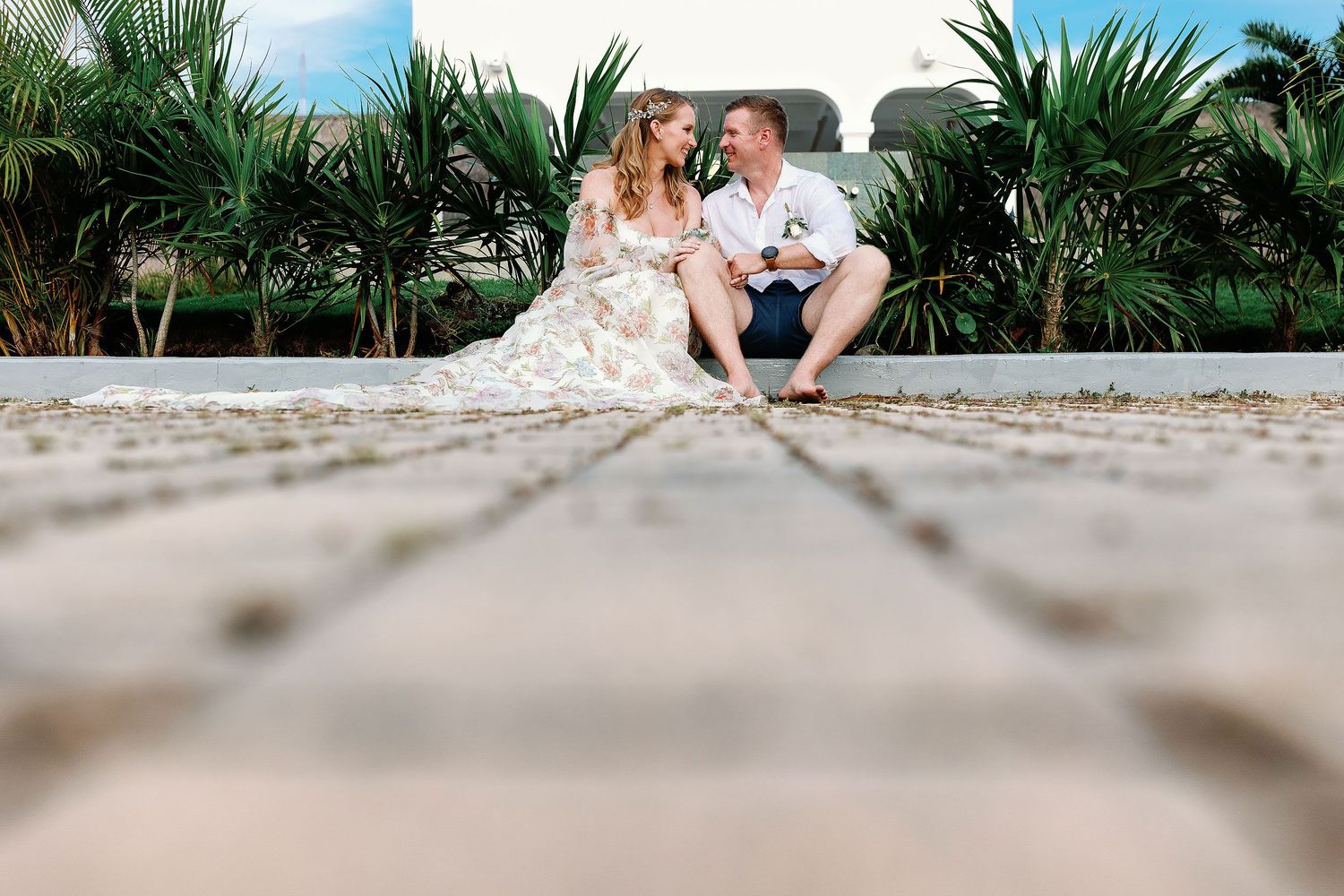 Autumn and Brian sitting barefoot together during their relaxed wedding portrait session at Dreams Sapphire.