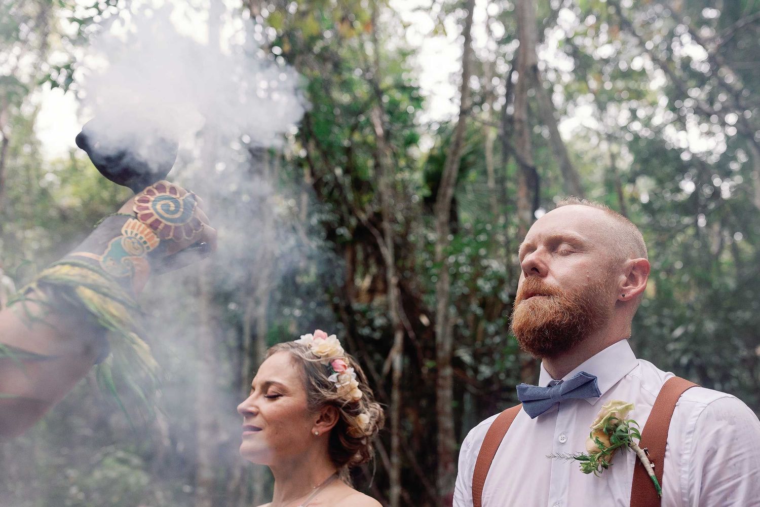 Jeff and Veronica receiving a ceremonial smoke blessing during their intimate Maya wedding ceremony at Cenote Hats’uts near Playa del Carmen