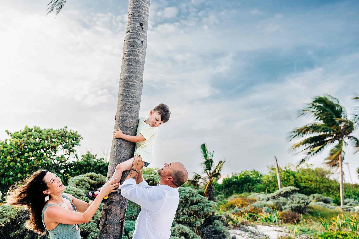 Happy family laughing together during a playful Riviera Maya beach photoshoot