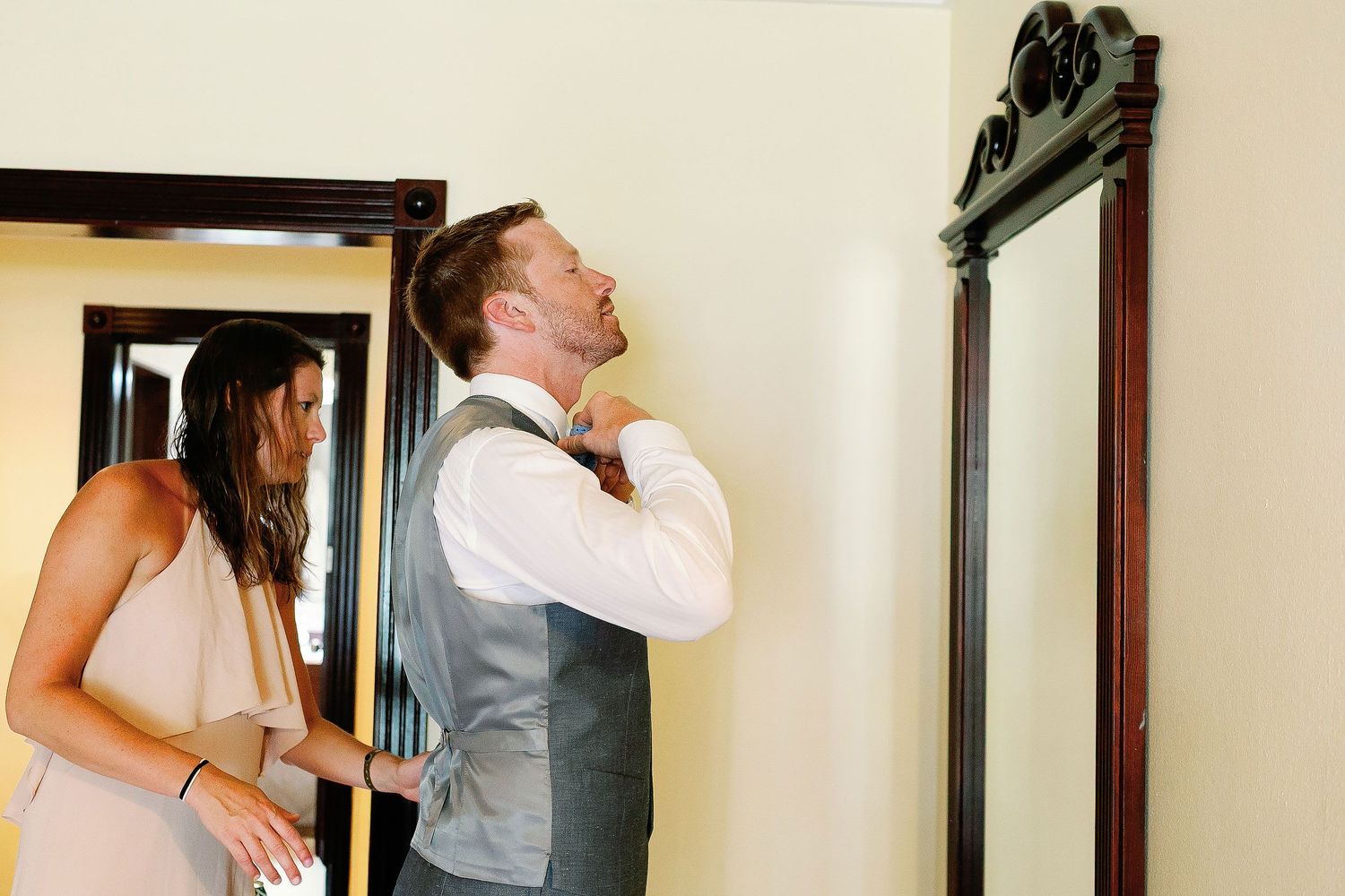 Alan adjusts his tie while a wedding attendant helps him prepare at Riu Palace Riviera Maya in Playacar, Playa del Carmen.