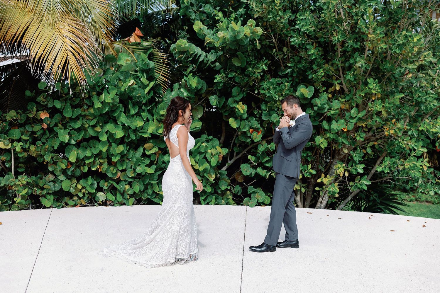 Emotional groom seeing his bride for the first time during their wedding first look amid tropical greenery at Haven Riviera Cancun.
