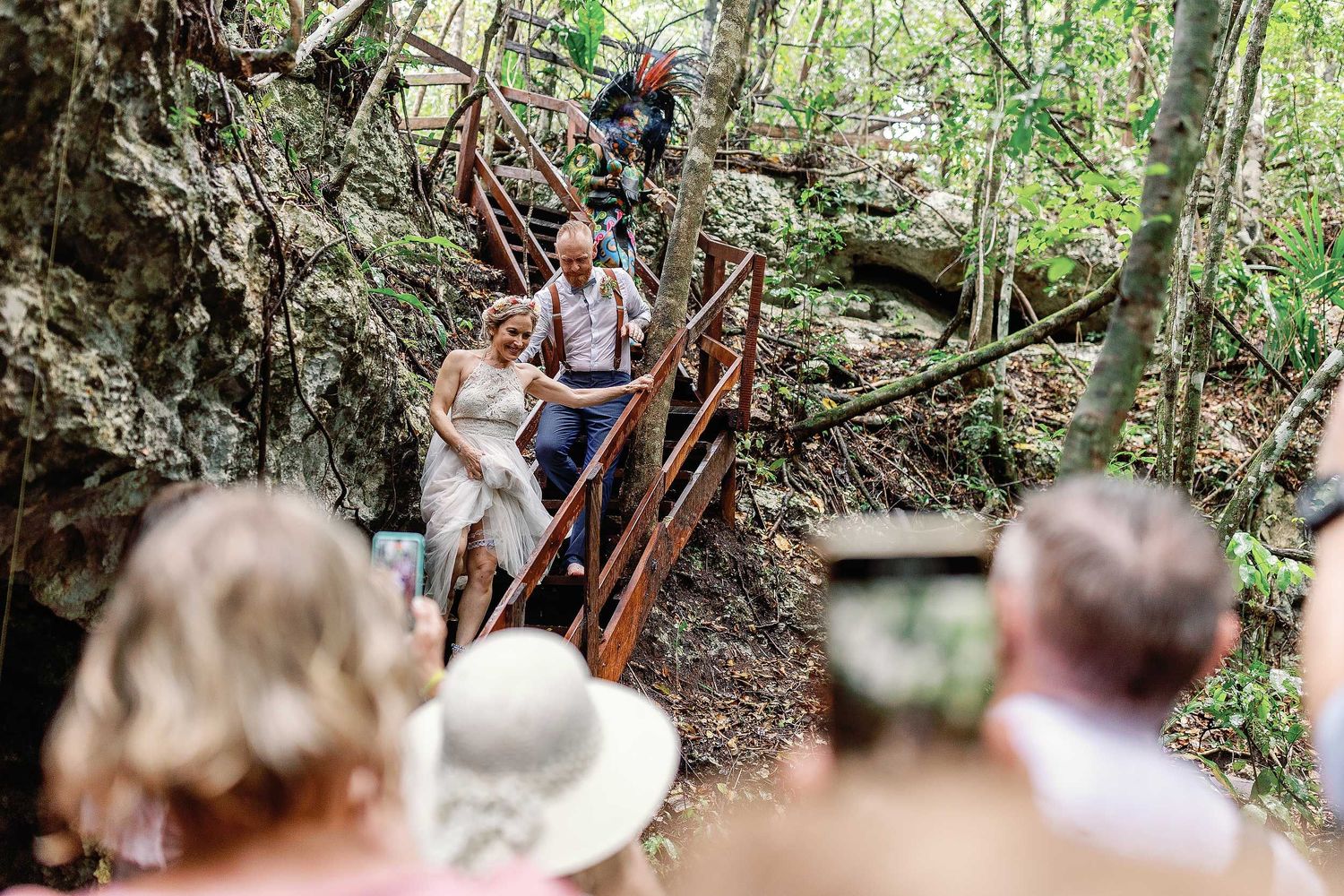 Jeff and Veronica descending the wooden stairs into Cenote Hats’uts for their intimate Maya wedding ceremony near Playa del Carmen.