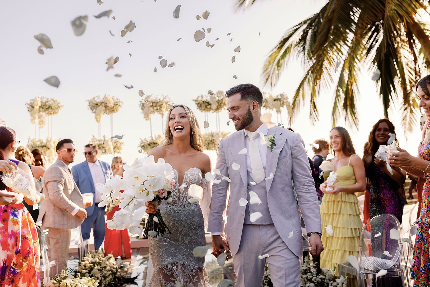 Bride and groom celebrating their wedding recessional with flower petals during a luxury beachfront ceremony in Punta Mita, Mexico.